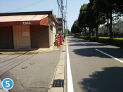 左側に「たばこ」の看板がある建物がございます。建物の手前の路地を左折してください。